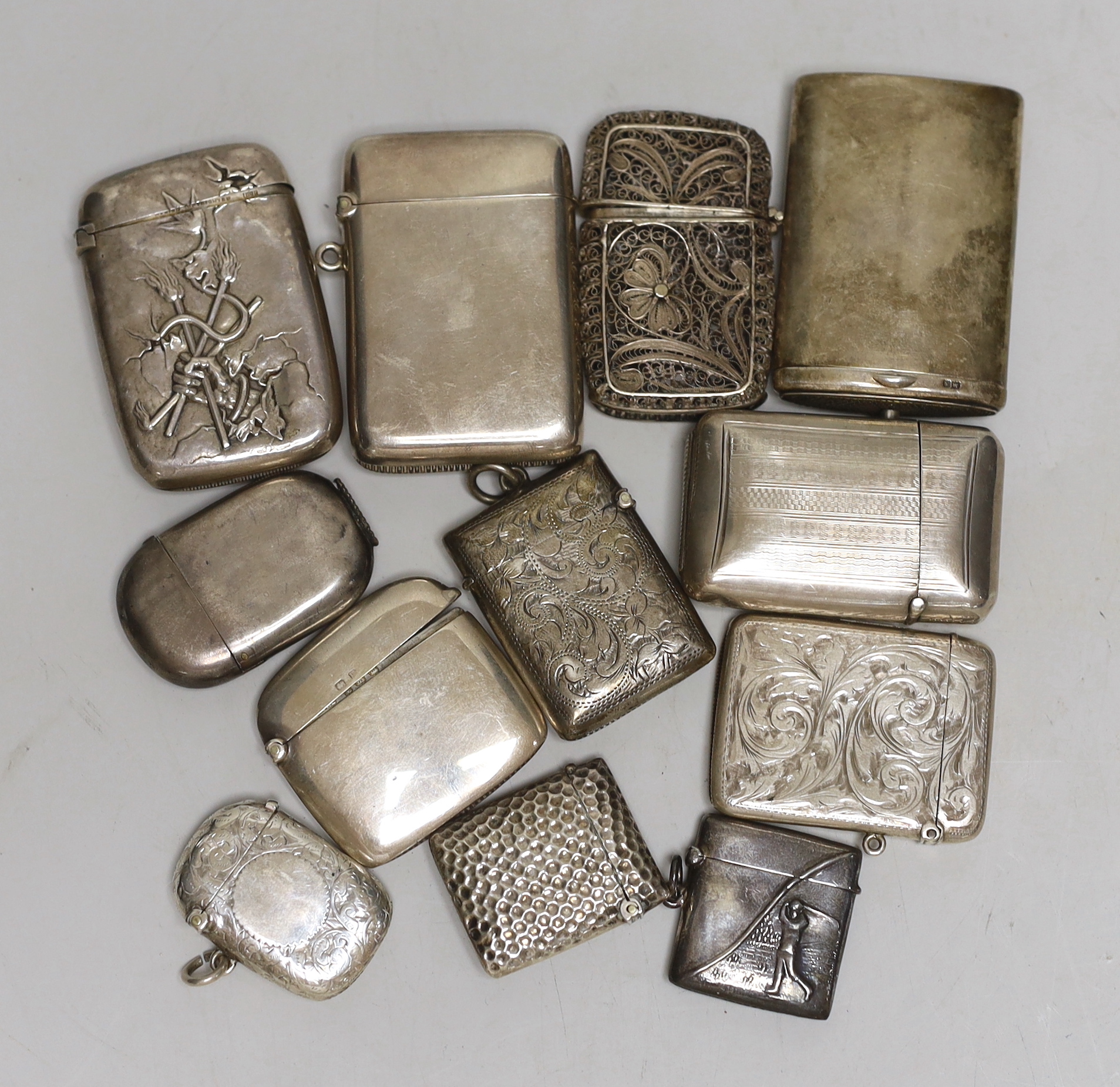 Nine assorted mainly early 20th century silver vesta cases, together with a filigree vesta case, a sterling vesta case embossed with a golfer and a 'Full of the D?' sterling vesta case, 61mm